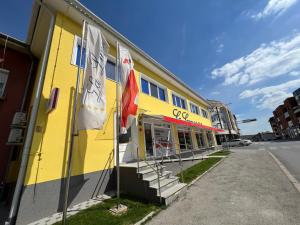 żółty budynek z flagami na boku w obiekcie La Luna Premium Deluxe Apartment with Free Jacuzzi, Bikes & Covered Parking w mieście Našice