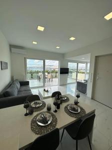 a living room with a table and chairs and a couch at Floisvos Penthouse Oasis in Athens