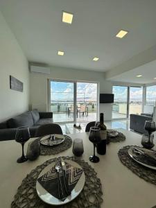a living room with a table with plates on it at Floisvos Penthouse Oasis in Athens +20 photos