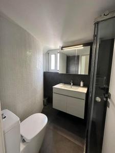 a bathroom with a white toilet and a sink at Floisvos Penthouse Oasis in Athens