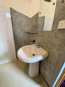 a bathroom with a white sink and a mirror at Weligama Imal Guest House in Weligama