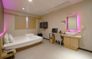 Nampo Comma Hotel في بوسان: غرفة الفندق بسرير ومغسلة ومرآة
