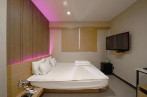 Säng eller sängar i ett rum på Nampo Comma Hotel