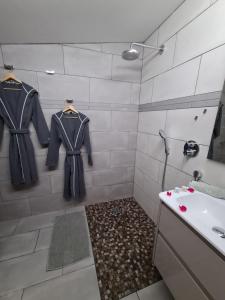 Baño con 2 chaquetas colgadas en una ducha en LES 2 CABANES en Labastide-Gabausse