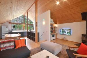 a living room with a couch and a tv at Muskoka House — Stunning architect-designed chalet in Hakuba +50 photos