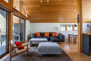 a living room with a couch and a table at Muskoka House — Stunning architect-designed chalet in Hakuba