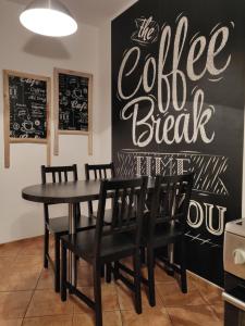 a dining room with a table and chairs and a chalkboard at Szarotka in Szczecin