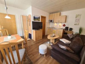 a living room and kitchen with a couch and a table at Gästehaus Andrea in Hahnenklee-Bockswiese