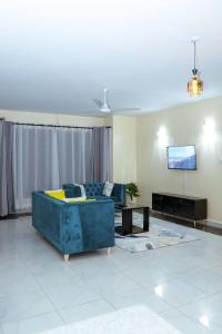 a living room with a blue couch and a tv at Orion Holidays in Mombasa