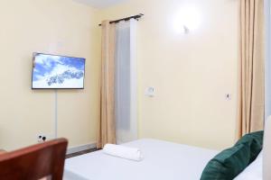a room with two beds and a tv on the wall at Orion Holidays in Mombasa