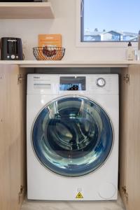 een blauwe wasmachine in een kamer bij The happy hideaway 2 bed 2 bath in Christchurch