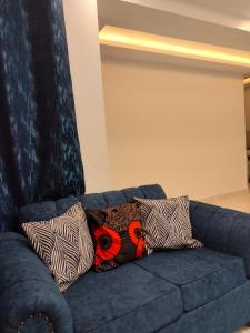 un sofá azul con almohadas encima en Kesuiyo Loft en Nairobi