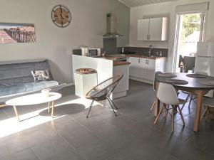 une cuisine et un salon avec une table et des chaises dans l'établissement La Petite Dune 800m de la Plage, à Bretignolles-sur-Mer