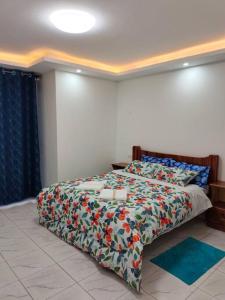 1 dormitorio con 1 cama con un edredón colorido en Kesuiyo Loft en Nairobi