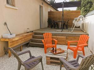 une terrasse avec 2 chaises et une table avec un parasol dans l'établissement La Petite Dune 800m de la Plage, à Bretignolles-sur-Mer
