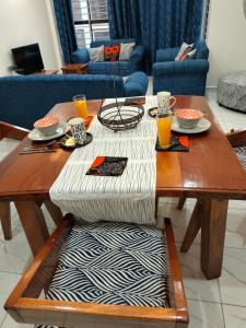 una mesa de madera con comida en la sala de estar en Kesuiyo Loft en Nairobi