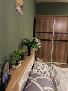 1 dormitorio con cama y macetas en un tocador en Cozy, Comfy Homestay, en Hithadhoo