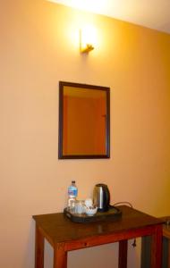 a mirror on a wall next to a table with food at Depche Village Resort in Bandīpur
