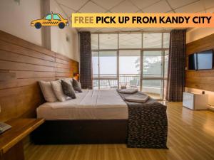 Un dormitorio con una cama grande con un coche. en Kandyan View Holiday Bungalow ''Free Pickup From Kandy city'' en Kandy
