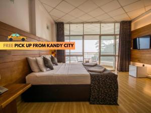 a bedroom with a large bed and a tv at Kandyan View Holiday Bungalow in Kandy