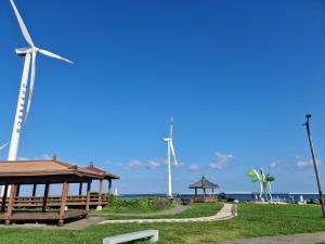 a park with a gazebo and wind turbines at Bibidoongdoong in Jeju