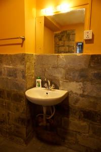 y baño con lavabo y espejo. en Depche Village Resort, en Bandipur