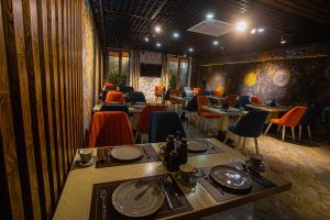 a dining room with tables and chairs in a restaurant at Florence Boutique Hotel by Hotel Pro group in Yakkasaray