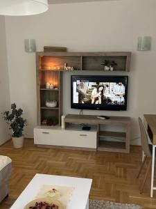 Big White M في Karaburma: غرفة معيشة مع تلفزيون بشاشة مسطحة على جدار