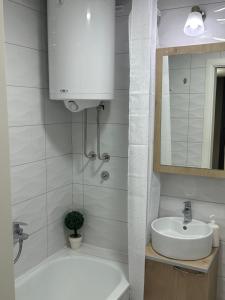 W łazience znajduje się umywalka, wanna i lustro. w obiekcie Big White M w mieście Karaburma