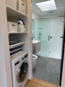 a bathroom with a washing machine and a shower at Ocean Waters in Mahia