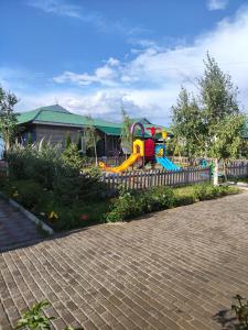 un parque infantil con un tobogán frente a una valla en Париж2, en Chok-Tal