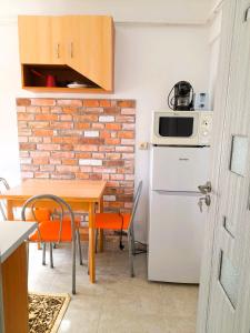 a kitchen with a table and a white refrigerator at Apartment Eminescu - A pleasant stay in Bacau in Bacău
