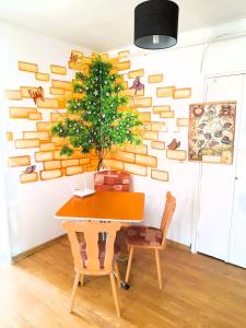 ein Esszimmer mit einem Tisch und einem Baum an der Wand in der Unterkunft Apartment Eminescu - A pleasant stay in Bacau in Bacău