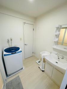 a white bathroom with a sink and a toilet at STUDIO YONEGAHAMA l 米が浜通 in Yokosuka