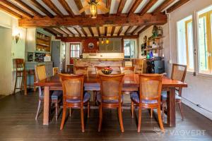 a dining room with a wooden table and chairs at Maison Bergoun in Borce