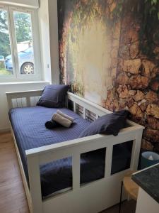 een bed in een kamer met een muur bij Petit Cocon - Dormir Comme A La Maison 