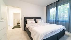 1 dormitorio con cama y ventana grande en Apartments by KEN, en Ramstein-Miesenbach