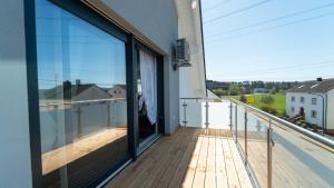 a balcony with glass doors and a view at Apartments by KEN in Ramstein-Miesenbach