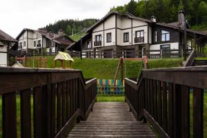 a wooden bridge with a playground in front of a house at Finlandia Chalet in Bukovel