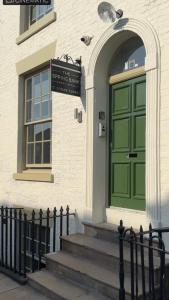 una puerta verde al lado de un edificio en The Spring Bank APARTHOTEL, en Preston