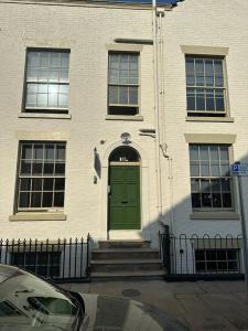 a green door on a building with a fence at The Spring Bank APARTHOTEL in Preston