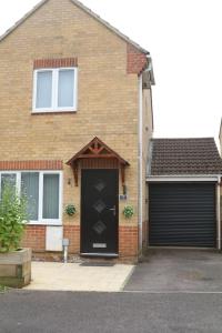 una casa de ladrillo con una puerta negra y un garaje en Coleridge house Private parking NETFLIX, en Swindon