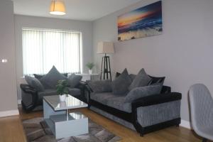 a living room with a couch and a table at Coleridge house Private parking NETFLIX in Swindon