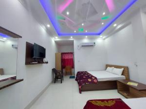 a room with two beds and a tv on the ceiling at Sea Wave Beach Resort in Tajpur