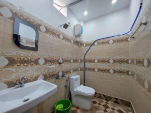 a bathroom with a sink and a toilet and a mirror at Sea Wave Beach Resort in Tajpur