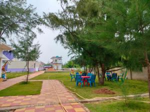 a patio with tables and chairs in a yard at Sea Wave Beach Resort in Tajpur