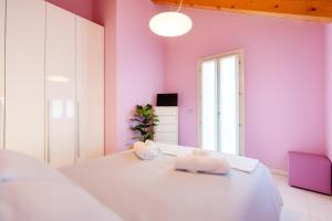 um quarto com paredes cor-de-rosa e uma cama com toalhas em Ca' Degli Antichi Giardini Apartments em Veneza