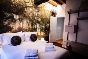 a bedroom with a white bed with towels on it at Old Town - Boutique Rooms in Modena