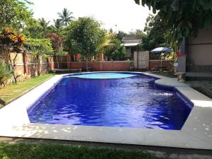 una piscina de agua azul en un patio en Bello Bungalow, en Batukliang