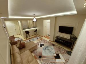 شارع كوين طريق كيلو ٨ في سفاجا: غرفة معيشة مع أريكة وتلفزيون بشاشة مسطحة
